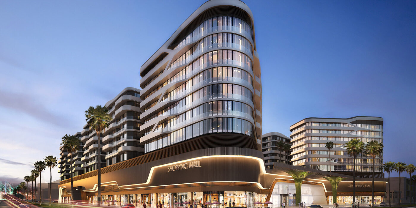 a large glass-fronted commercial building behind a road and palm trees