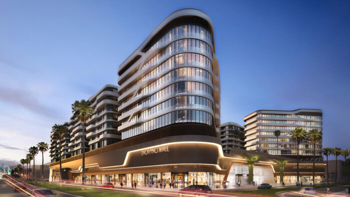 a large glass-fronted commercial building behind a road and palm trees